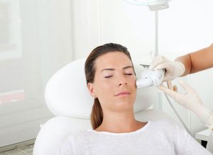 Strahlung des Gesichts mit Ultherapy: Attraktive Frau während der Behandlung.